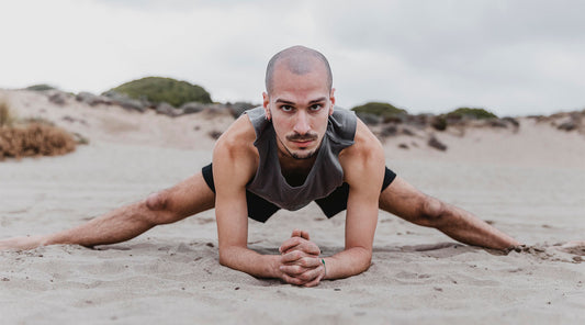 front-view-man-beach-exercising-yoga-positions-sand