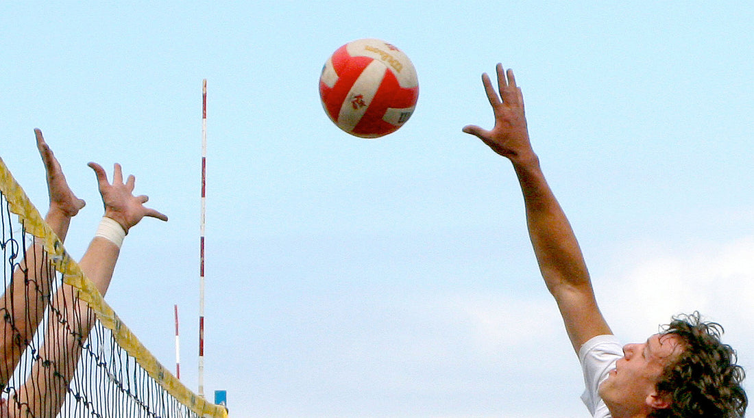 beach volleyball players spike and defence