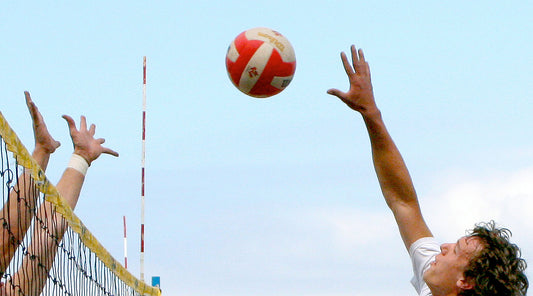 beach volleyball players spike and defence