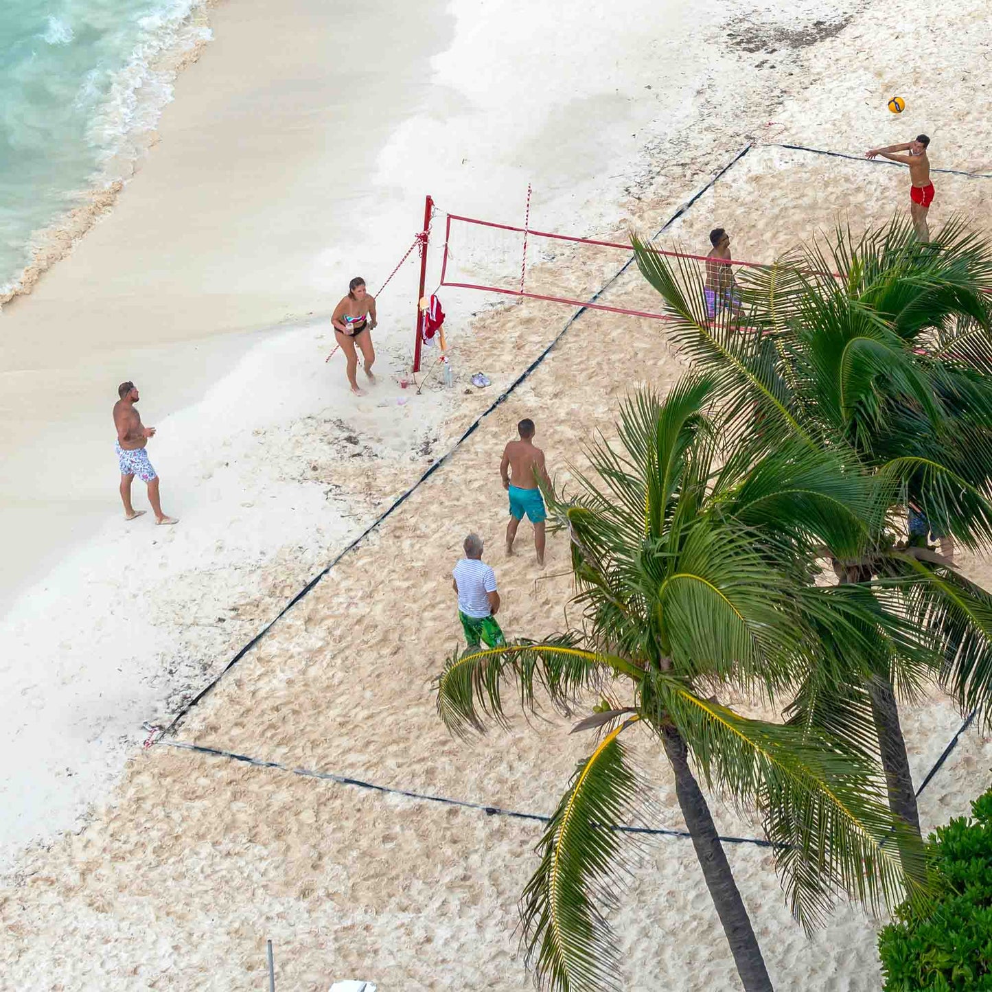 tourist playing volleyball on the beach