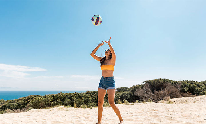 happy-woman-playing-with-ball-beach