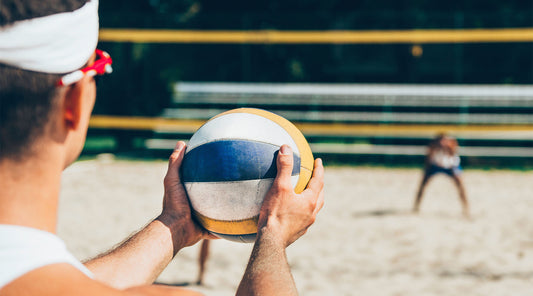 beach volleyball player about to serve a ball